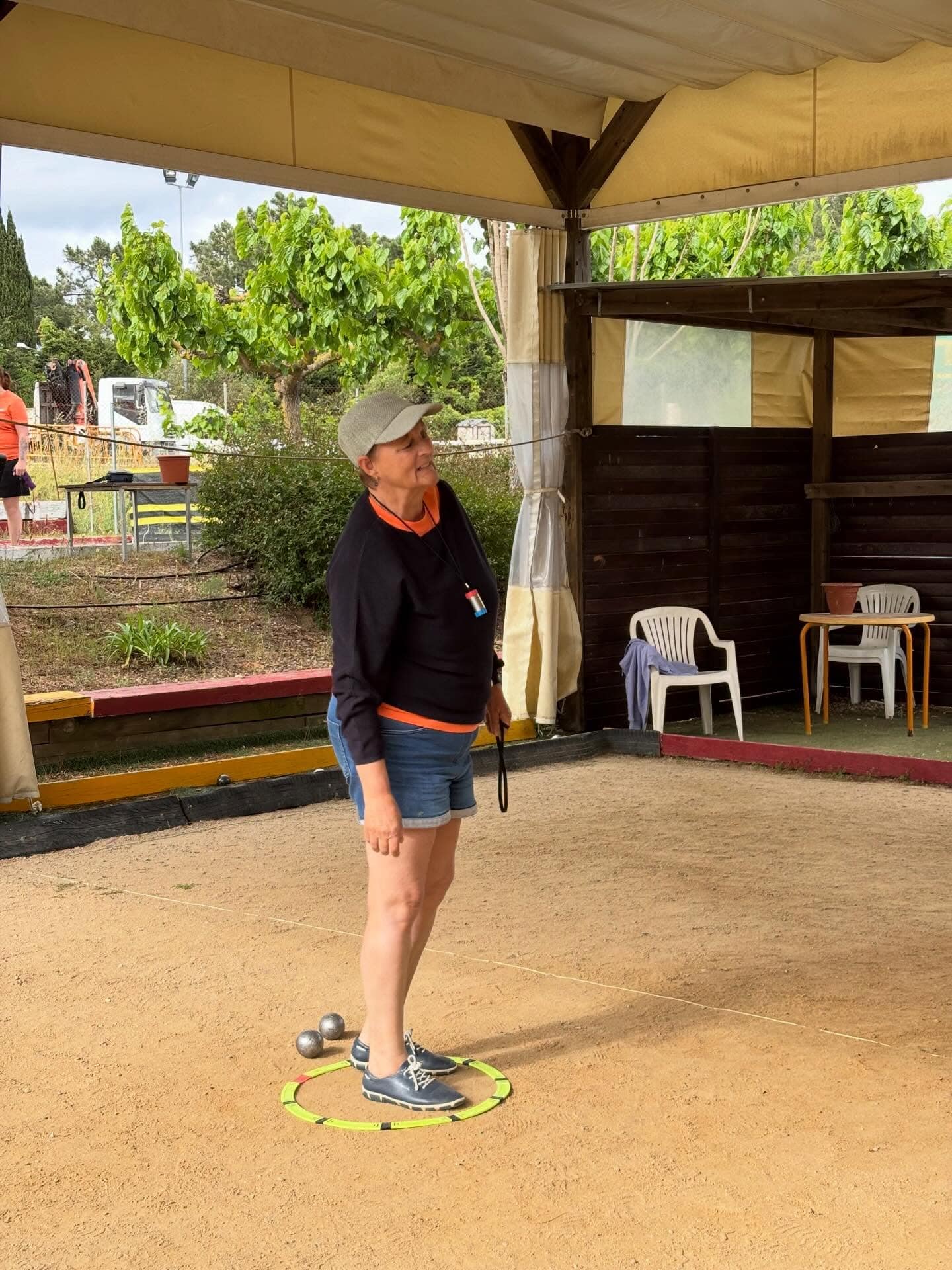 Femme jouant à la pétanque dans un terrain extérieur en plein air.