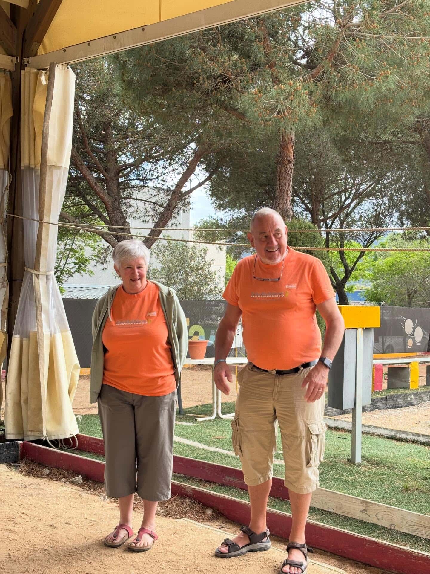 Deux personnes âgées profitant d'une journée en extérieur sous un arbre.