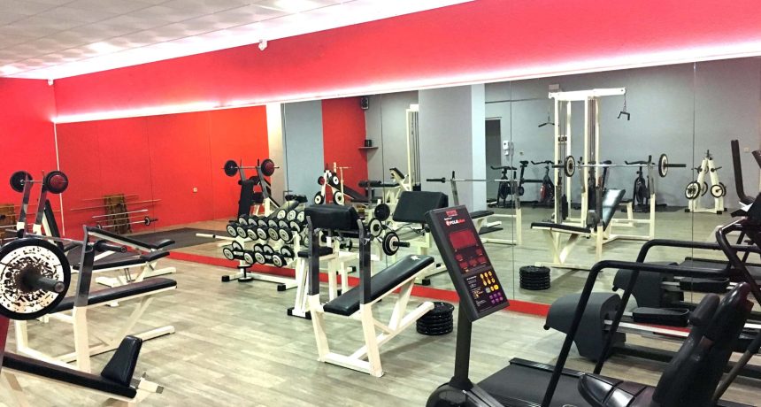 Salle de sport avec équipements de musculation et cardio.