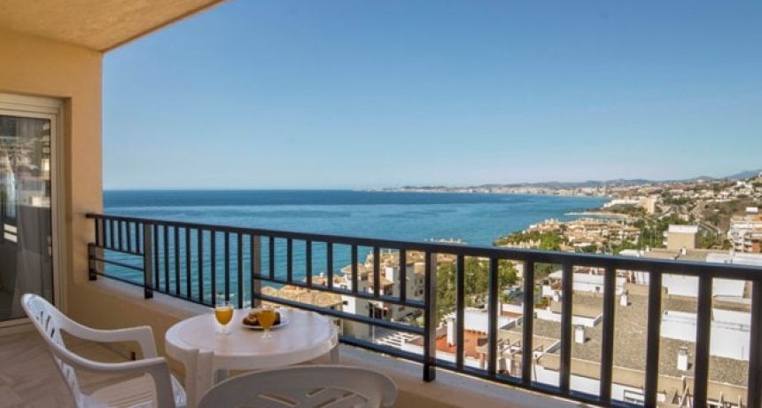 Balcon avec vue sur la mer et la côte ensoleillée.