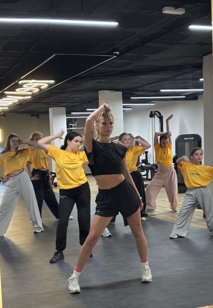 Groupe de jeunes danseurs en entraînement dans un studio de danse moderne.