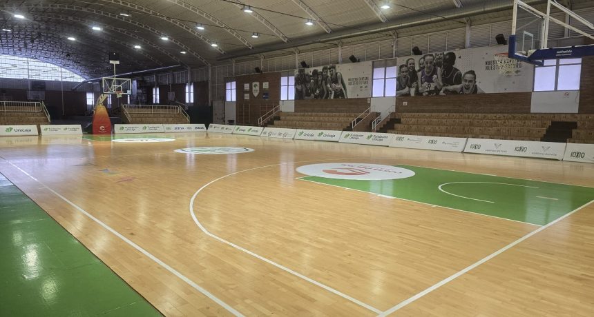 Intérieur d'une salle de basketball avec parquet et paniers.